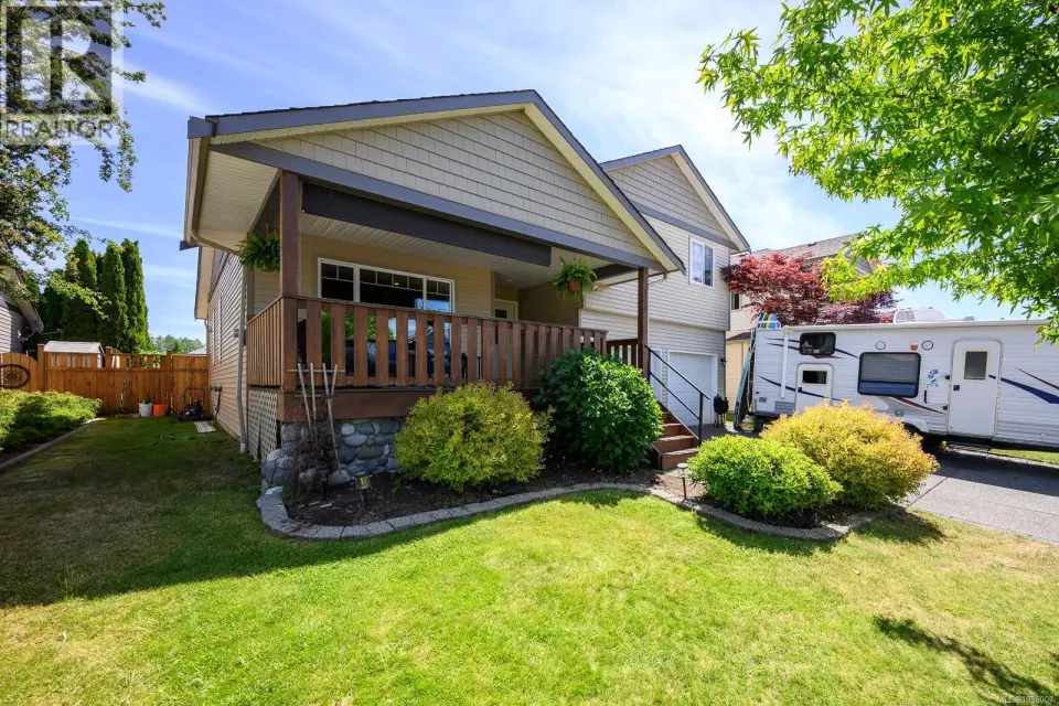 Two-story home featuring RV parking, elevated front deck with exterior living space and double garage.