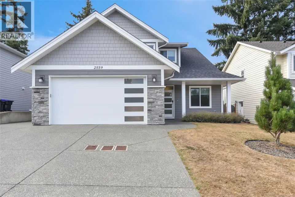 2018 construction, immaculate condition, main-level primary, quartz finishes, heat pump, custom garage, EV charger, fenced yard and peaceful green-space backdrop.