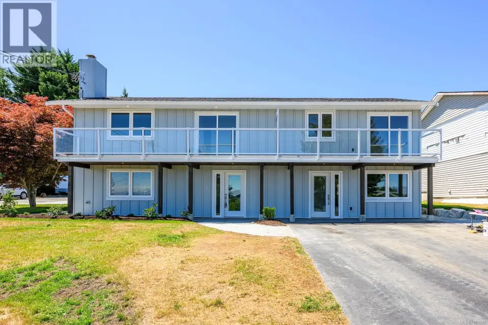 Side-by-side duplexes. Light blue, wood exterior with a second-story balcony featuring glass panel railings and frosted divider.